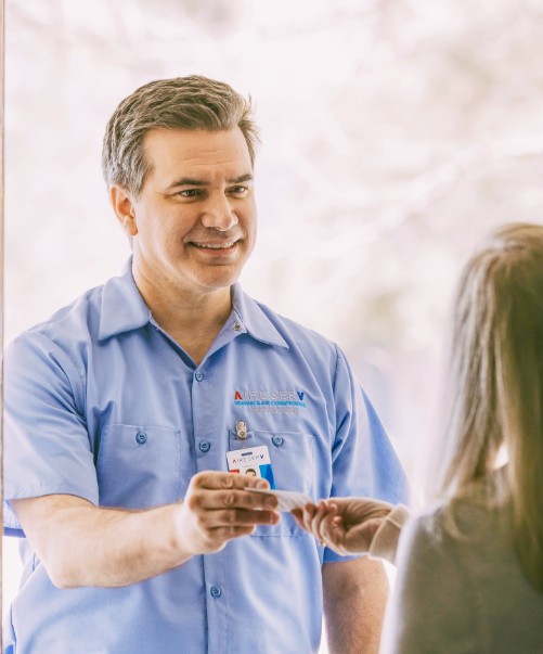 a client handing Aire Serv technician a check
